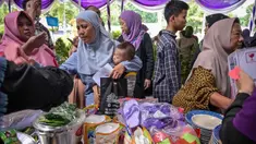 Masyarakat menerima barang-barang gratis seperti pakaian, bahan makanan pokok, dan perlengkapan rumah tangga yang disediakan oleh Asosiasi Organisasi Wanita (GOW) dan pemerintah daerah selama kegiatan aksi sosial tahunan di bulan Ramadan, Surabaya pada Senin 2 Maret 2026. Bersama Pemerintah Kota Surabaya, Jawa Timur, Gabungan Organisasi Wanita (GOW) aksi sosial tahunan, berupa peendistribusian berbagai barang bantuan kepada warga yang membutuhkan. (JUNI KRISWANTO/AFP)