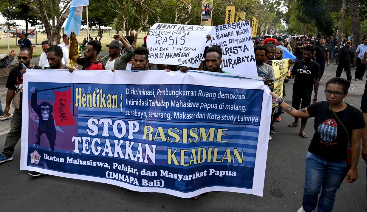 Ikatan Mahasiswa Pelajar dan Masyarakat Papua (IMMAPA) membawa spanduk saat berunjuk rasa di Lapangan Niti Mandala, Denpasar, Bali, Kamis (22/8/2019). Massa bawa spanduk bertulis 'Kami Bukan Monyet Kami Manusia Stop Rasis' hingga 'Stop Rasisme!! Kami Orang Papua Bukan Monyet'. (SONNY TUMBELAKA/AFP)