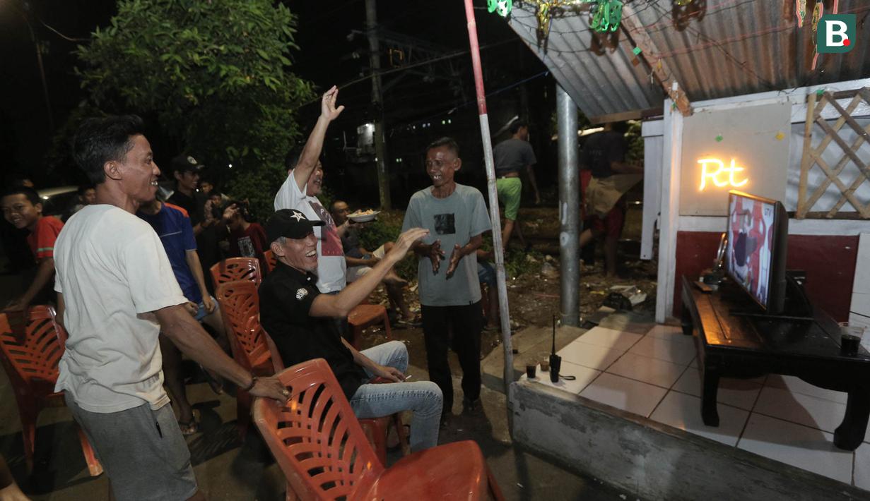 Sejumlah warga meluapkan kebahagiaan setelah Timnas Indonsia mengalahkan Bahrain dalam pertandingan Grup C putaran ketiga Kualifikasi Piala Dunia 2026 zona Asia di kawasan Menteng Jaya, Jakarta, Selasa (25/5/2025). (Bola.com/M Iqbal Ichsan)