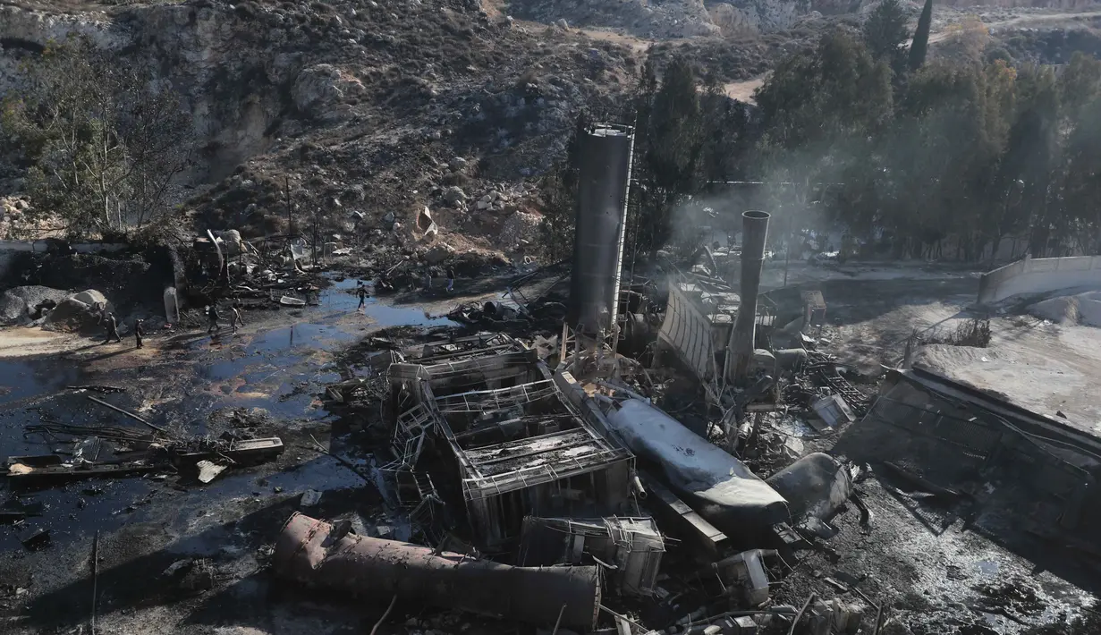 Orang-orang memeriksa kerusakan di pabrik semen yang disebabkan oleh serangan udara Israel di desa Ansar, Lebanon Selatan, pada Jumat 17 Oktober 2025. (AP Photo/Mohammad Zaatari)