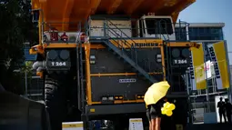 Salah satu SPG berdiri di depan sebuah truk pertambangan yang dipamerkan dalam ajang "Expomin 2014", sebuah pameran dua tahunan pertambangan di Santiago, Chili, (21/4/2014). (REUTERS/Ivan Alvarado)