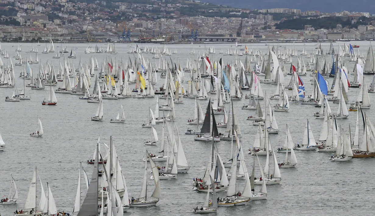 Ribuan kapal berlayar untuk memulai perlombaan tahunan Barcolana di sekitar Pelabuhan Trieste, Italia, Minggu (11/10). Barcolana merupakan salah satu perlombaan kapal layar tahunan terbesar di dunia yang dimulai sejak 1969. (REUTERS/Stefano Rellandini)