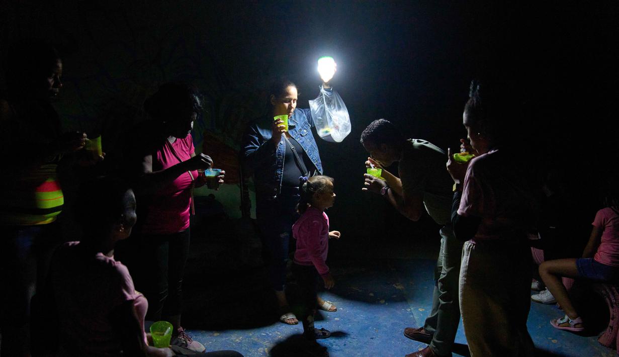 Sebagai informasi, krisis listrik telah lama melanda Kuba. Tampak dalam foto, seorang pria memberi seorang gadis sesendok sup di jalanan saat pemadaman listrik di Havana, Kuba, Rabu 4 Maret 2026. (AP Photo/Ramon Espinosa)