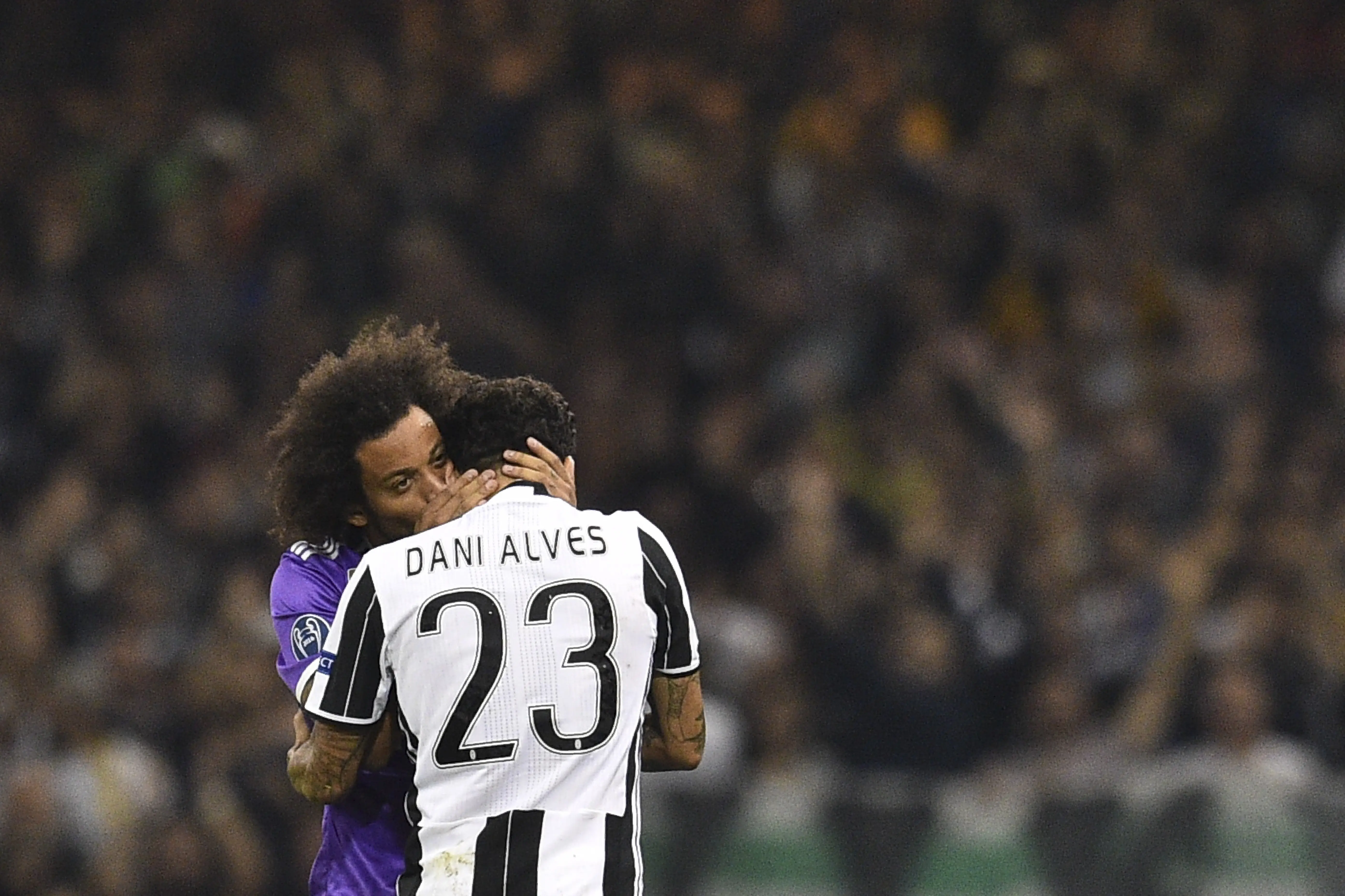 Bek kanan Juventus, Dani Alves mendapat pelukan dari bek kiri Real Madrid, Marcelo usai final Liga Champions 2016/2017. (Glyn KIRK / AFP)