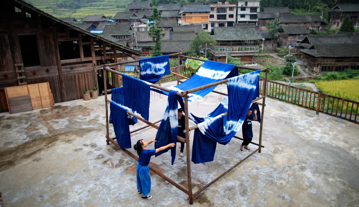 Sejumlah perempuan menjemur kain di sebuah bengkel kerja di Desa Etnis Dong Fengdeng di Wilayah Rongjiang, Provinsi Guizhou, China pada 6 September 2020. Warga setempat memanfaatkan kondisi cuaca musim gugur yang mendukung untuk membuat kain tradisional kelompok etnis Dong. (Xinhua/Liu Xu)
