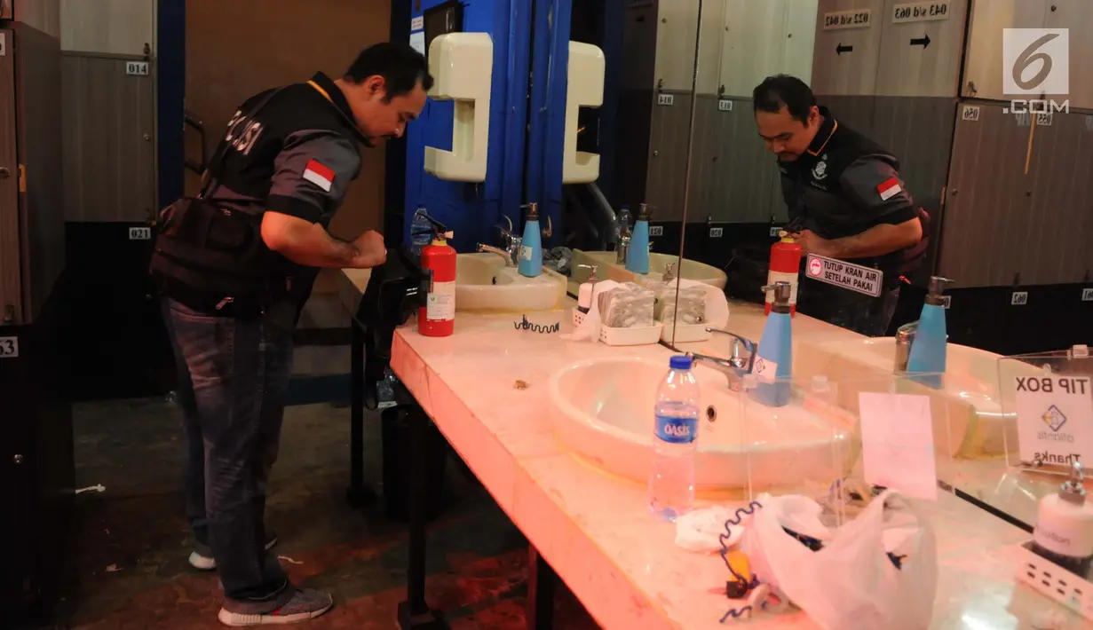Petugas berada di salah satu ruangan tempat pesta gay di Kelapa Gading, Jakarta, Selasa (23/5). Polisi telah mengamankan 141 orang pria dan menetapkan 10 orang tersangka. (Liputan6.com/Gempur M Surya)