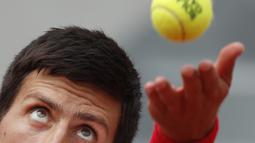Ekspresi wajah petenis Serbia, Novak Djokovic melakukan servis saat melawan petenis Spanyol, Jaume Munar pada ajang Prancis Terbuka 2018 di Roland Garros stadium, Paris, France, (30/5/2018). (AP/Christophe Ena)