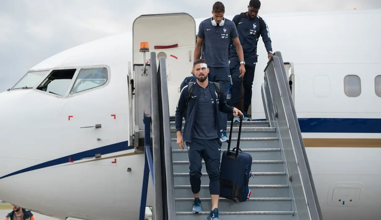 Penyerang Timnas Prancis,  Olivier Giroud dan rekan-rekan setimnya turun dari pesawat setibanya di bandara Sheremetyevo Moskow, Minggu (10/6). Giroud dengan kepala diperban ikut dalam rombongan yang akan berlaga di Piala Dunia 2018. (AP/Pavel Golovkin)