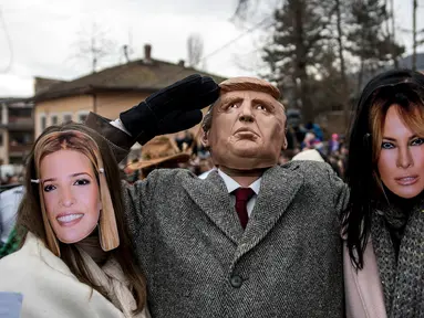 Peserta berpakaian seperti Ivanka Trump, Presiden AS Donald Trump dan Melania Trump saat mengikuti karnaval di desa Vevcani, Macedonia (13/1). Karnaval Vevcani ini selalu digelar setiap tahunnya dan telah berusia 1,400 tahun.(AFP Photo/Robert Atanasovski)