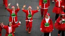 Peserta berkostum Sinterklas melambaikan tangan saat mengikuti Santa Claus Run di Madrid, Spanyol, Minggu (9/12). Ribuan orang berjalan dan berlari dalam perlombaan Santa tahunan melintasi jalan-jalan ibu kota Spanyol. (Gabriel BOUYS / AFP)
