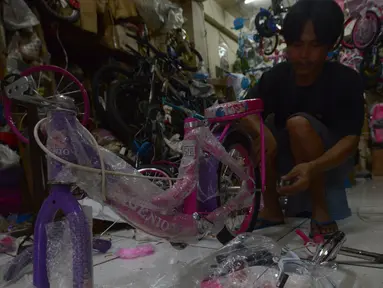 Penjaga toko sedang merakit sepeda di toko sepeda Kramat Jati, Jakarta, Selasa (7/12/2021). Pandemi Covid-19 yang sedang terjadi membuat tren olahraga bersepeda semakin banyak diminati mulai dari anak-anak hingga orang dewasa dan lanjut usia. (merdeka.com/Imam Buhori)