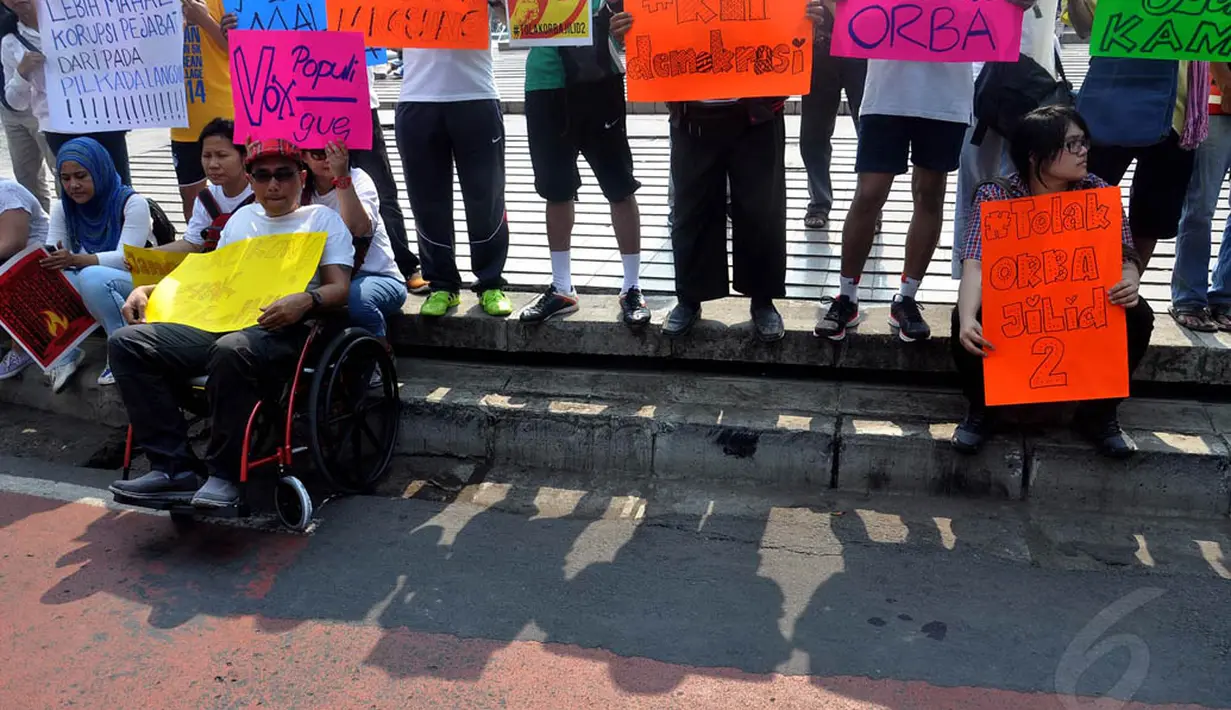 Seorang pria yang duduk di kursi roda ikut menggelar aksi menolak UU Pilkada di Bundaran HI, Jakarta, (28/9/14). (Liputan6.com/Miftahul Hayat)