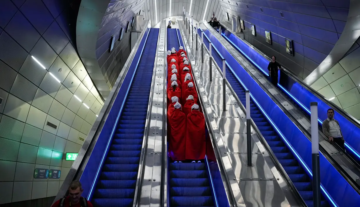 Pengunjuk rasa yang mendukung hak-hak perempuan berpakaian seperti karakter dari serial TV "The Handmaid's Tale" saat melakukan perjalanan untuk memprotes rencana pemerintah baru Perdana Menteri Benjamin Netanyahu untuk merombak sistem peradilan di sebuah stasiun kereta api di Yerusalem, Israel, 1 Maret 2023. Mengacu pada fenomena yang berkembang, harian Inggris The Guardian menggambarkan penampilan para pelayan sebagai salah satu simbol paling kuat dari protes feminis kontemporer. (AP Photo/Ohad Zwigenberg)