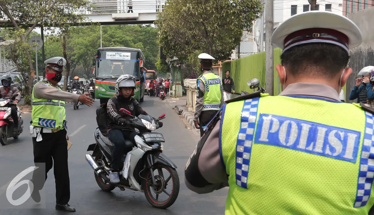 Petugas polisi saat memberhentikan pengendara motor di kawasan Cempaka Putih, Jakarta, Senin (26/10/2015). Operasi Zebra 2015 berlangsung hingga 4 November 2015 bertujuan untuk menekan pelanggaran lalulintas. (Liputan6.Com/Angga Yuniar)