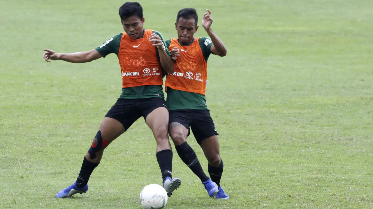Pemain Timnas Indonesia U-22, Nurhidayat Haris, berebut bola dengan Dallen Doke saat latihan. (Bola.com/Yoppy Renato)