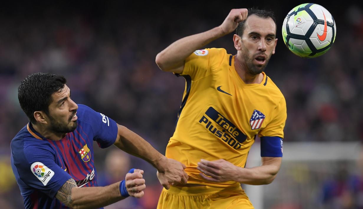 Bek Atletico Madrid, Diego Godin, duel udara dengan striker Barcelona, Luis Suarez, pada laga La Liga Spanyol di Stadion Camp Nou, Barcelona, Minggu (4/3/2018). Barcelona menang 1-0 atas Atletico. (AFP/Lluis Gene)