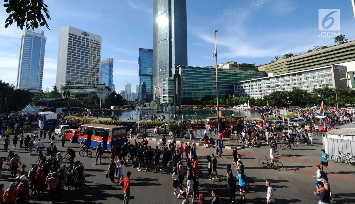 Warga berjalan di kawasan Bundaran Hotel Indonesia, Jakarta, Minggu (31/12). Meski pelaksanaan Hari Bebas Kendaraan dipenghujung 2017 ditiadakan, warga tetap memadati area CFD. (Liputan6.com/Helmi Fithriansyah)