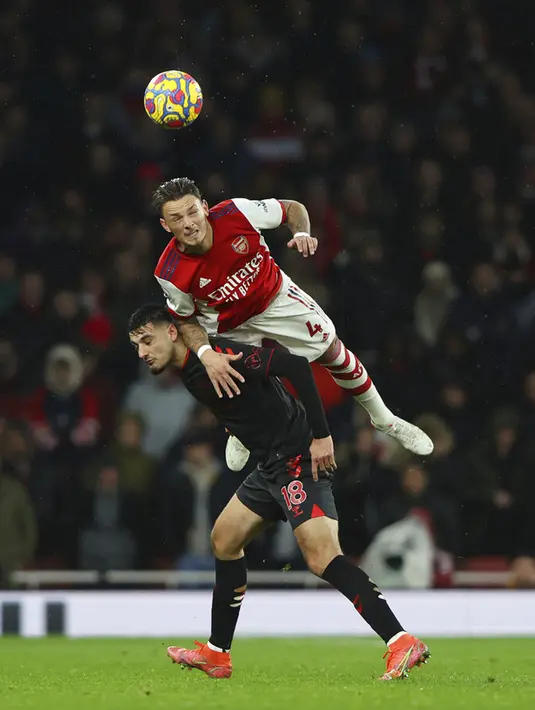 Pemain Arsenal Ben White menyundul bola melewati pemain Southampton Armando Broja pada pertandingan sepak bola Liga Inggris di Emirates Stadium, London, Inggris, 11 Desember 2021. Arsenal menang 3-0. (AP Photo/Ian Walton)