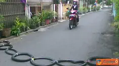 Citizen6, Yogyakarta: Pengendara sepeda motor melewati "polisi tidur" yang terbuat dari ban bekas yang disambung dengan tali, di jalan Cokrodipuran, Yogyakarta. (Pengirim: Heru Prasetyo)