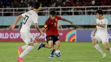 Pemain Timnas Spanyol U-17, Marc Guiu (tengah), mengontrol bola dibayangi dua pemain Timnas Uzbekistan U-17 dalam laga pamungkas Grup B Piala Dunia U-17 2023 yang berlangsung di Stadion Manahan, Solo, Kamis (16/11/2023) sore WIB. (Bola.com/Arief Bagus Prasetiyo)