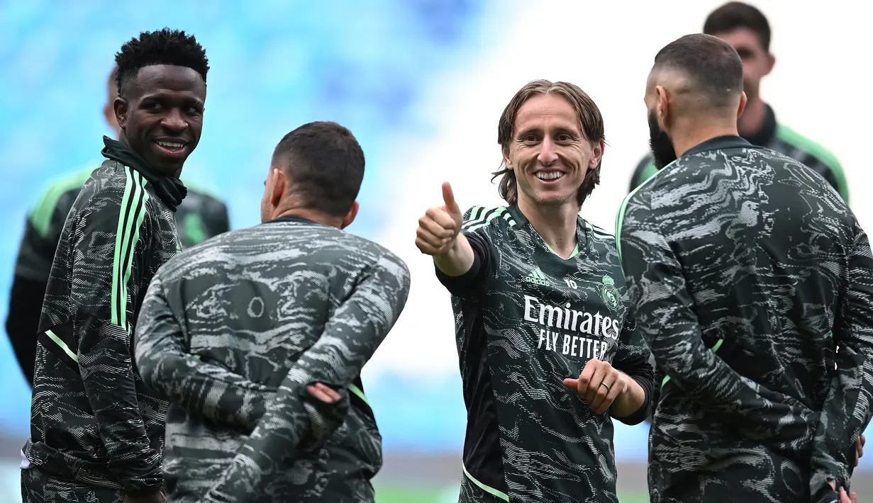 Pemain Real Madrid, Luka Modric (tengah) bercanda dengan rekannya saat melakukan latihan menjelang laga semifinal Liga Champions 2022/2023 melawan Manchester City di Etihad Stadium, Manchester, Selasa (16/05/2023) waktu setempat. (AFP/Oli Scarff)