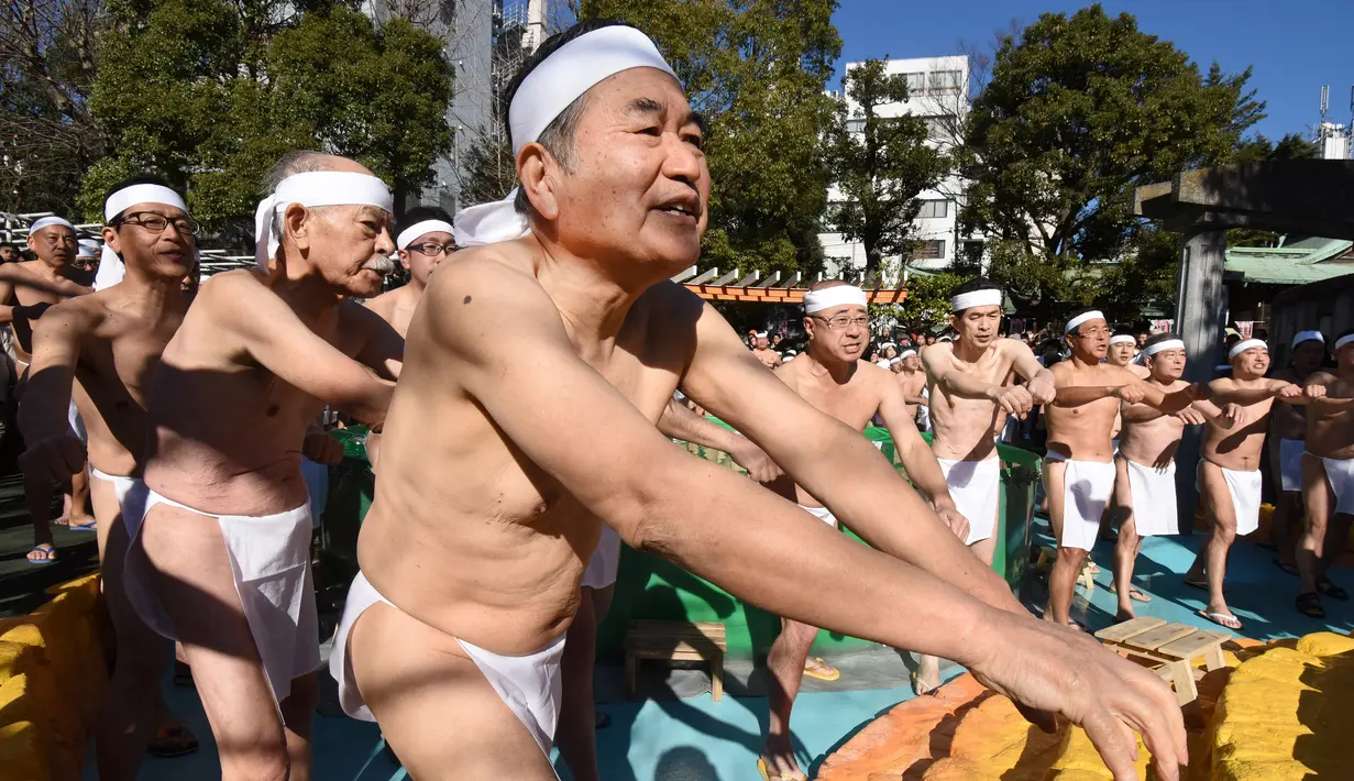 Penganut Shinto melakukan pemanasan sebelum memasuki kolam renang es untuk berdoa dan memurnikan tubuh dan jiwa dalam ritual Upacara Penyucian di Tokyo, Minggu (10/01/2016). (AFP Photo/ Toru Yamanaka)