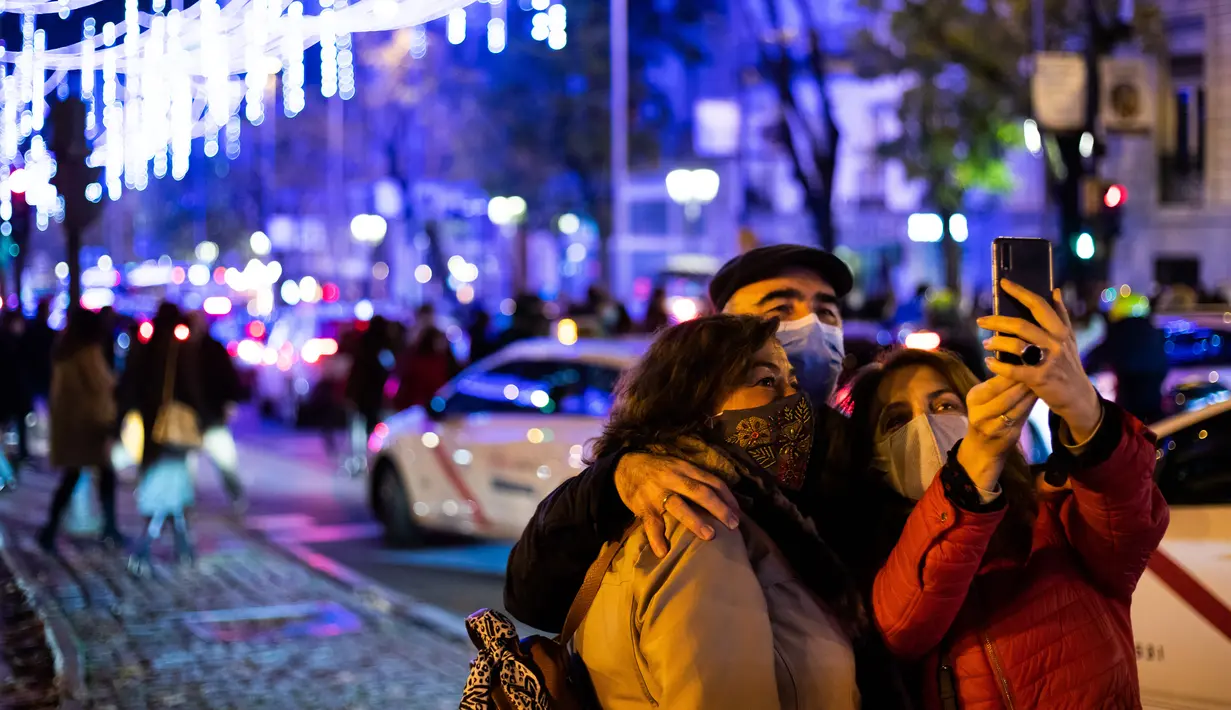 Warga berswafoto di sebuah jalan yang didekorasi dengan lampu- lampu hias di Madrid, ibu kota Spanyol, pada 28 November 2020. Lampu-lampu hias untuk menyemarakkan perayaan Natal itu dipasang mulai 26 November 2020 hingga 6 Januari 2021. (Xinhua/Meng Dingbo)