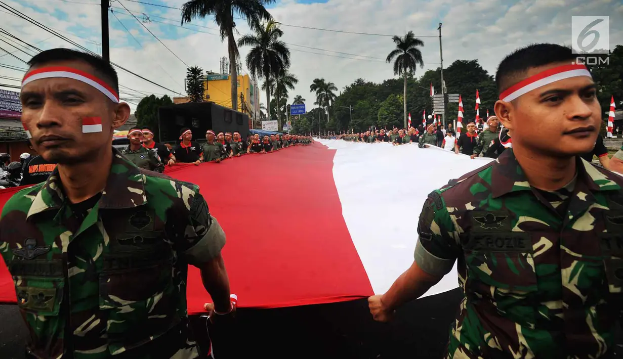 Anggota TNI POLRI  membawa bendera raksasa saat gelaran Festival Merah-Putih (FMP) 2018 di kawasan Air Mancur, Bogor,  Minggu (5/8). Bendera tersebut berukuran panjang 117 meter dan lebar 5 meter. (Merdeka.com/Arie Basuki)