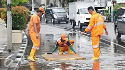 Petugas menggunakan busa untuk membersihkan genangan air di Harmoni, Jakarta, Selasa (9/2). Buruknya sistem drainase membuat petugas terpaksa harus membersihkan genangan setiap kali hujan, meski dengan peralatan seadanya. (Liputan6.com/Immanuel Antonius)