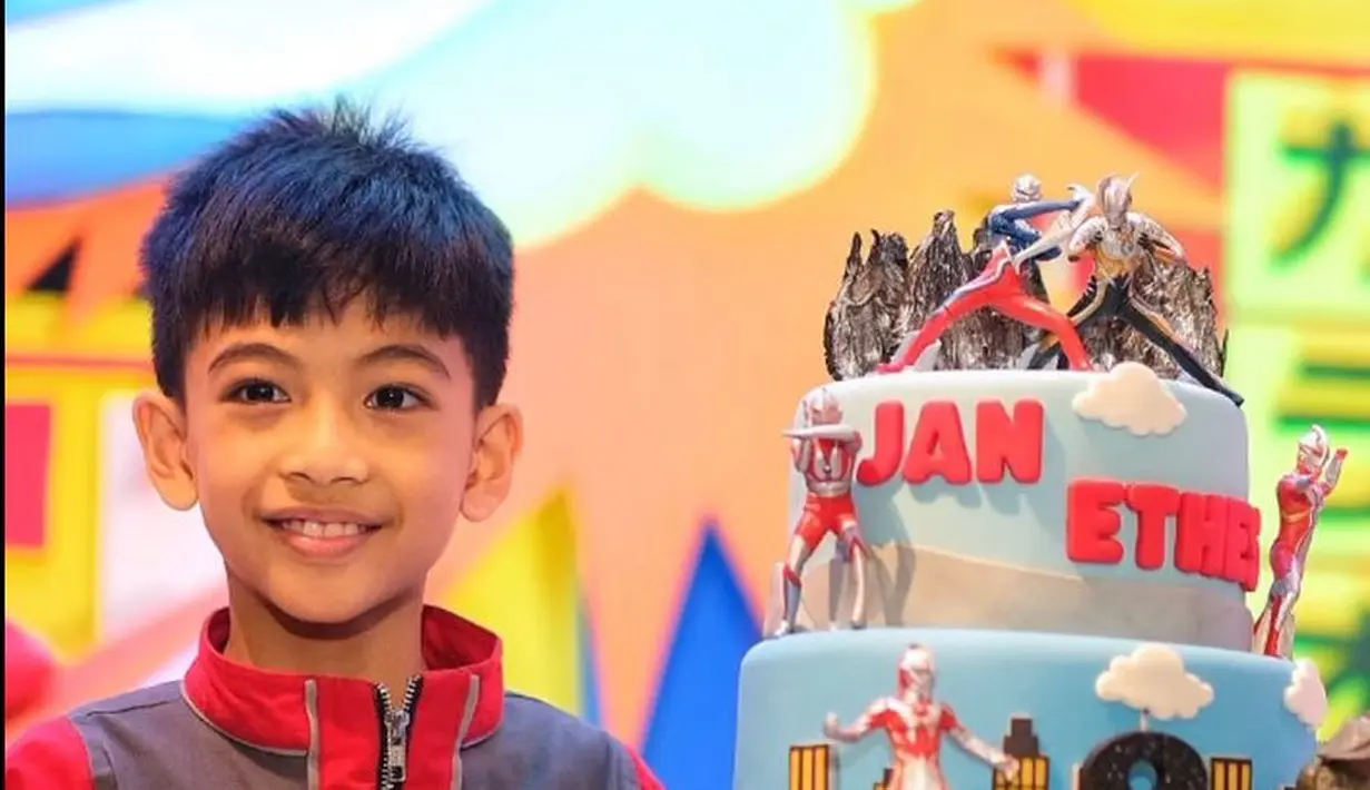 Jan Ethes pun berfoto bersama kue ulang tahun bertingkat warna biru dengan miniatur Ultraman. Tampak Jan Ethes pun semakin besar dengan senyum di wajahnya. (@jimboengbakoelsoto)