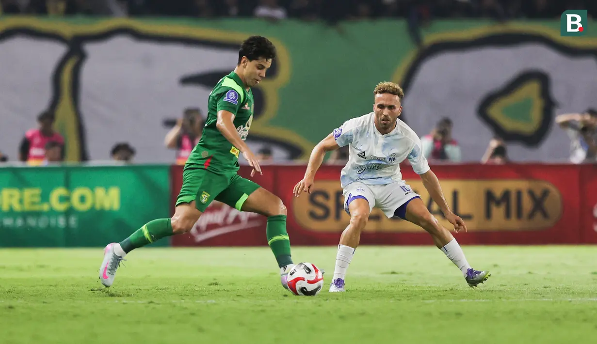 Pemain Persebaya Surabaya, Bruno Moreira (kanan) dijaga ketat oleh pemain PSIM Yogyakarta, Ze Valente pada pertandingan pembuka BRI Super League 2025/2026 di Stadion Gelora Bung Tomo, Jumat (08/08/2025) malam WIB. (Bola.com/Abdul Aziz)