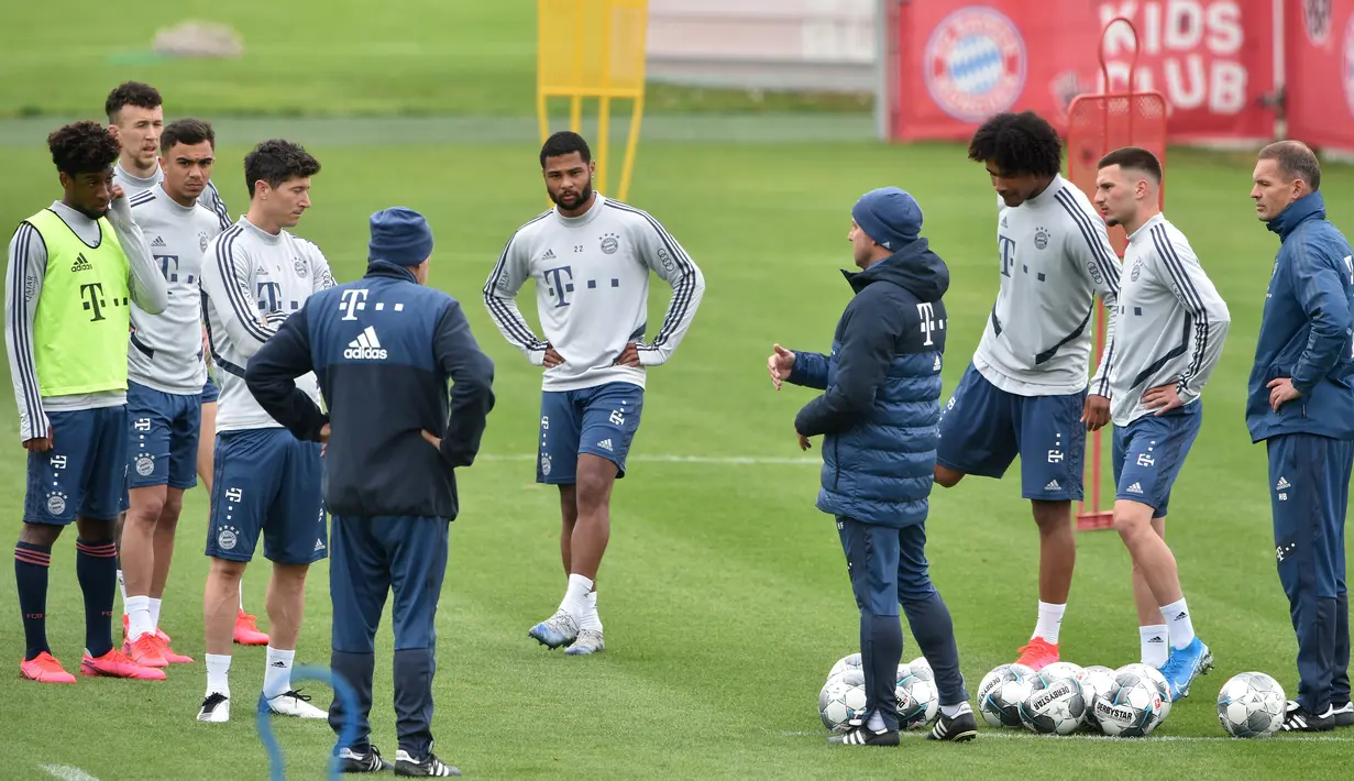 Pelatih Bayern Munchen Hansi Flick (tengah) berbicara kepada para pemainnya saat sesi latihan di Munich, Jerman, Selasa (5/5/2020). Bundesliga direncanakan kembali bergulir setelah otoritas setempat mulai melonggarkan lockdown untuk pencegahan penyebaran COVID-19. (Christof STACHE/AFP)