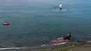 Sebuah kapal menarik paus mati dari pantai dekat Puerto Madryn, Argentina, Selasa (4/10/2022). Ilmuwan Argentina sedang menentukan penyebab pasti kematian belasan paus di Teluk Nuevo tersebut. (AP Photo/Maxi Jonas)