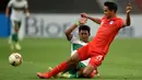 Pemain Singapura Safuwan Baharudin (kanan) berebut bola dengan pemain Indonesia Dedik Setiawan pada pertandingan leg pertama semifinal Piala AFF 2020 di National Stadium, Singapura, Rabu (22/12/2021). Pertandingan berakhir imbang 1-1. (Roslan RAHMAN/AFP)