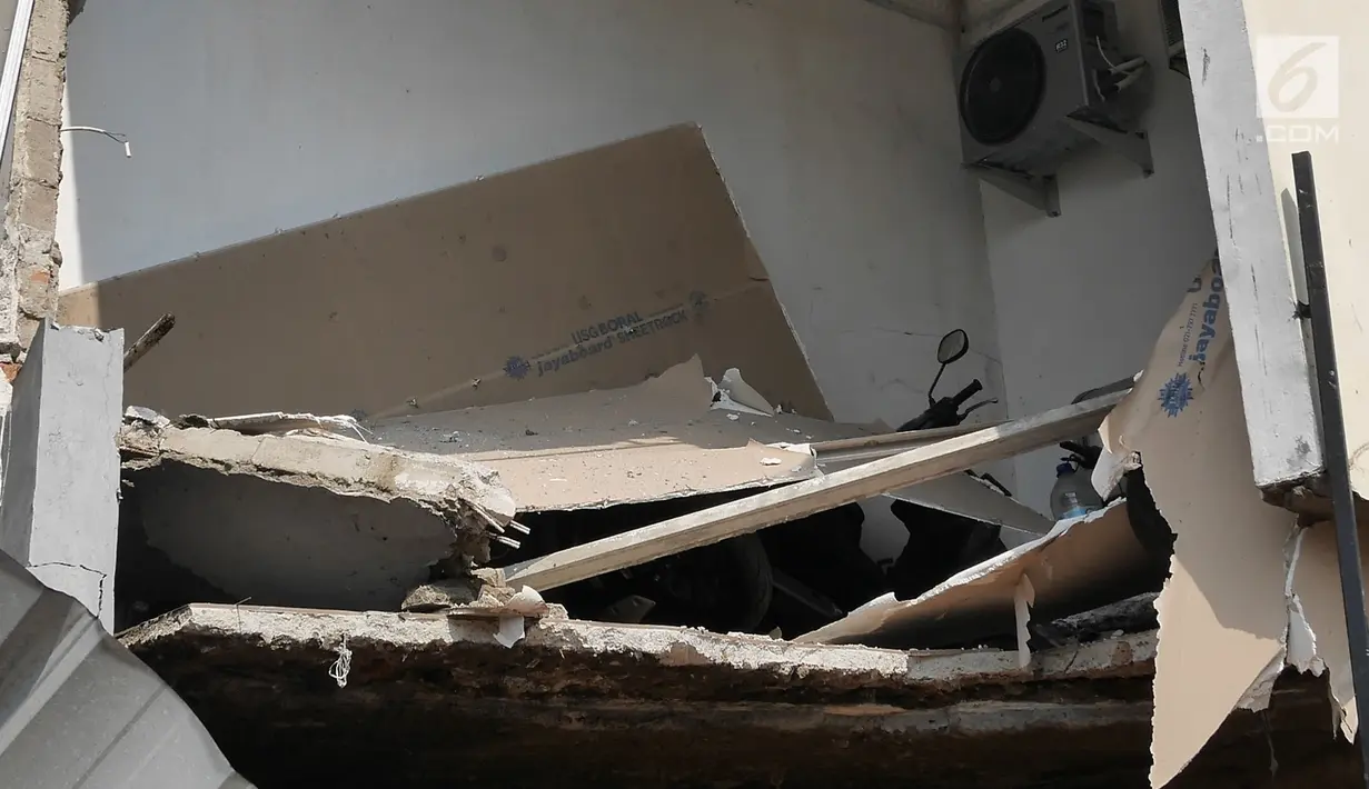 Sebuah sepeda motor tertimbun puing rumah yang rusak akibat longsor di Perumahan Pesona Kalisari, Pasar Rebo, Jakarta, Selasa (27/11). Longsor menyebabkan satu rumah rusak dan dua unit sepeda motor tertimbun. (Liputan6.com/Herman Zakharia)