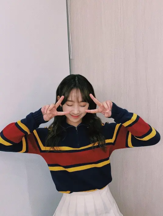 Tampil preppy, di sini Dita Karang terlihat mengenakan atasan berkerah lengan panjang bermotif garis bernuansa gelap, dipadunya dengan mini skirt putih polos. Ia juga membiarkan rambut panjangnya tergerai begitu saja dengan poni. Foto: Instagram.