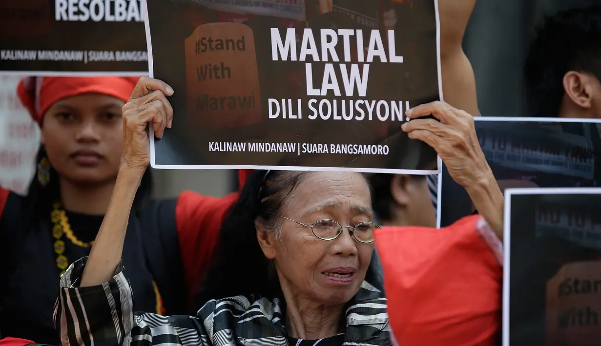 Sejumlah orang menggelar aksi menentang deklarasi darurat militer di depan Gedung DPR Filipina, Manila, Rabu (31/5). Darurat militer yang diberlakukan oleh Presiden Rodrigo Duterte justru akan membuka potensi pelanggaran HAM. (AP Photo / Aaron Favila)