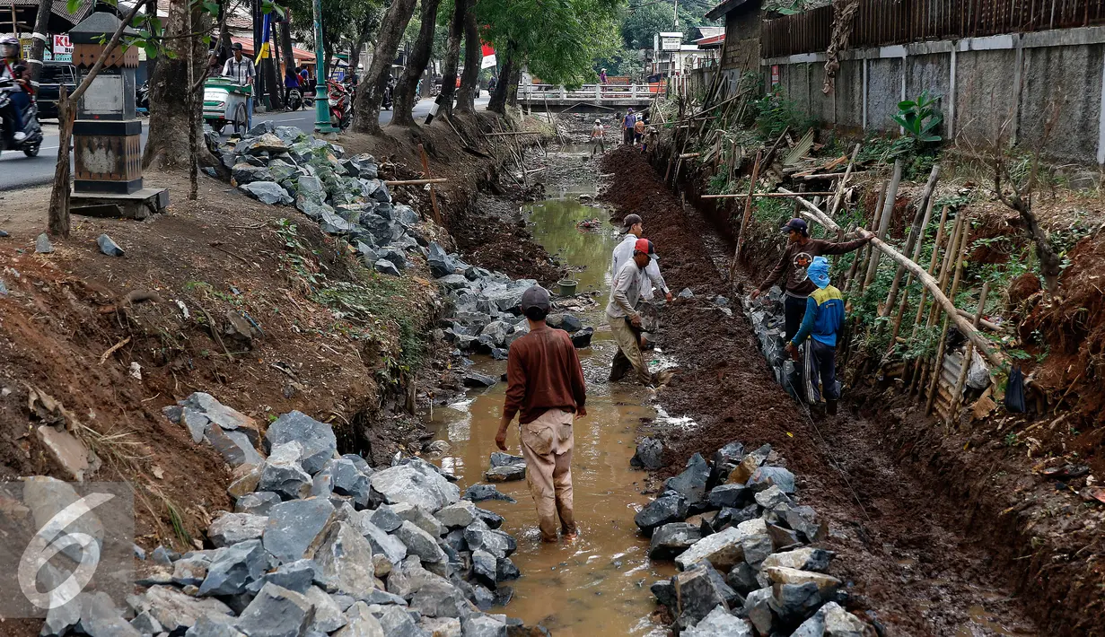 Pekerja menumpuk batu kali yang akan dijadikan sebagai pondasi turap di pinggiran kali Tanah Baru, Jakarta Selatan, Jumat (9/10/2015). Pemerintah kota Jaksel melakukan pemasangan turap untuk mengatasi kelongosoran tanah. (Liputan6.com/Yoppy Renato)