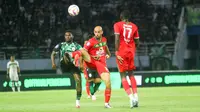 Ricky Cawor dan Mohammed Rashid berebut bola saat Persebaya Surabaya menjamu PSS Sleman di Stadion Gelora Bung Tomo, Minggu (11/8/2024) malam WIB. (Bola.com/Aditya Wany)