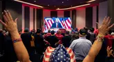 Para hadirin bersorak saat menyaksikan siaran mantan Presiden AS dan kandidat presiden dari Partai Republik Donald Trump yang ditampilkan di layar saat gelaran nonton bareng pemilihan GOP Nevada di Las Vegas, Nevada pada 6 November 2024. (Ronda Churchill/AFP)