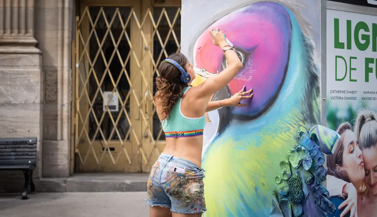 Seorang seniman mural melukis karya seni di Saint-Laurent Boulevard saat Festival Mural Montreal, Quebec, Kanada, 16 Juni 2022. Pengunjung dapat melihat lebih dari 100 mural masa lalu dan baru di lingkungan pusat kota metropolis berbahasa Prancis yang dilukis oleh seniman dari Kanada dan seluruh dunia. (Paola Chapdelaine/AFP)