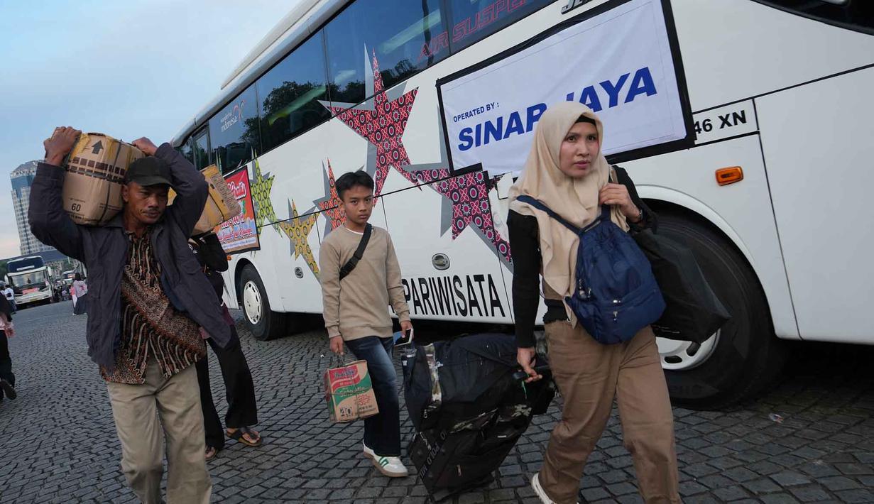 Sebagai informasi, program mudik gratis 2026 uang diselenggarakan Pemerintah Provinsi DKI Jakarta juga bertujuan untuk menekan penggunaan sepeda motor saat mudik guna mengurangi risiko kecelakaan di jalan raya. Tampak dalam foto, orang-orang membawa barang-barang mereka saat tiba untuk perjalanan mudik gratis yang diselenggarakan oleh Pemerintah Provinsi Jakarta di Lapangan Monumen Nasional, Selasa 17 Maret 2026. (AP Photo/Achmad Ibrahim)