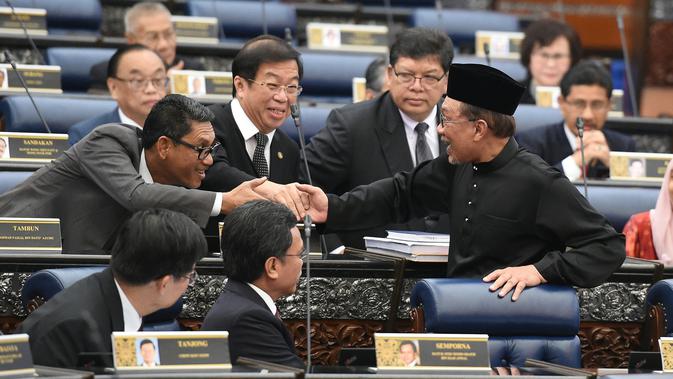 Pemimpin Partai Keadilan Rakyat Malaysia, Anwar Ibrahim menerima ucapan selamat seusai pelantikan sebagai anggota parlemen di Gedung Parlemen, Senin (15/10). Anwar Ibrahim dilantik sebagai anggota parlemen setelah memenangi pemilu sela. (MOHD RASFAN/AFP)