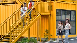 Para wisatawan muda terlihat di rumah berwarna-warni yang terbuat dari kontainer kargo di Desa Beilian yang berada di Xiyang, Kota Meizhou, Provinsi Guangdong, China selatan (24/11/2020). (Xinhua/Li He)