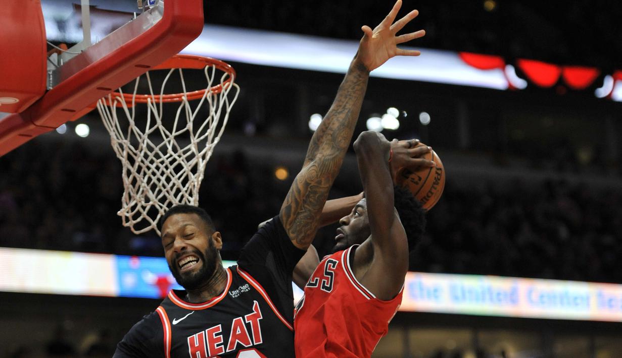 Aksi pemain Chicago Bulls, Justin Holiday (kanan) melakukan tembakan saat diadang pemain Miami Heat, James Johnson (kiri) pada laga NBA basketball game di United Center, Chicago, (26/11/2017). Miami Heat menang 100-93.  (AP/Paul Beaty)
