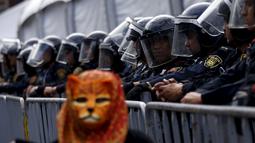 Petugas berjaga saat protes menandai ulang tahun sebelas bulan hilangnya 43 siswa yang hilang di Meksiko (26/8/2015). Para mahasiswa menghilang sejak 26 September 2014 di kota barat daya Iguala. (REUTERS/Henry Romero)