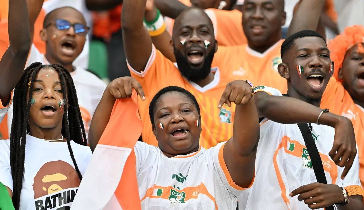 Sejumlah penonton bersorak saat pesta pembukaan Piala Afrika 2023 yang berlangsung di Stadion Alassane Ouattara Olympic, Abidjan, Pantai Gading, Minggu (14/01/2024) dini hari WIB. (AFP/Issouf Sanogo)
