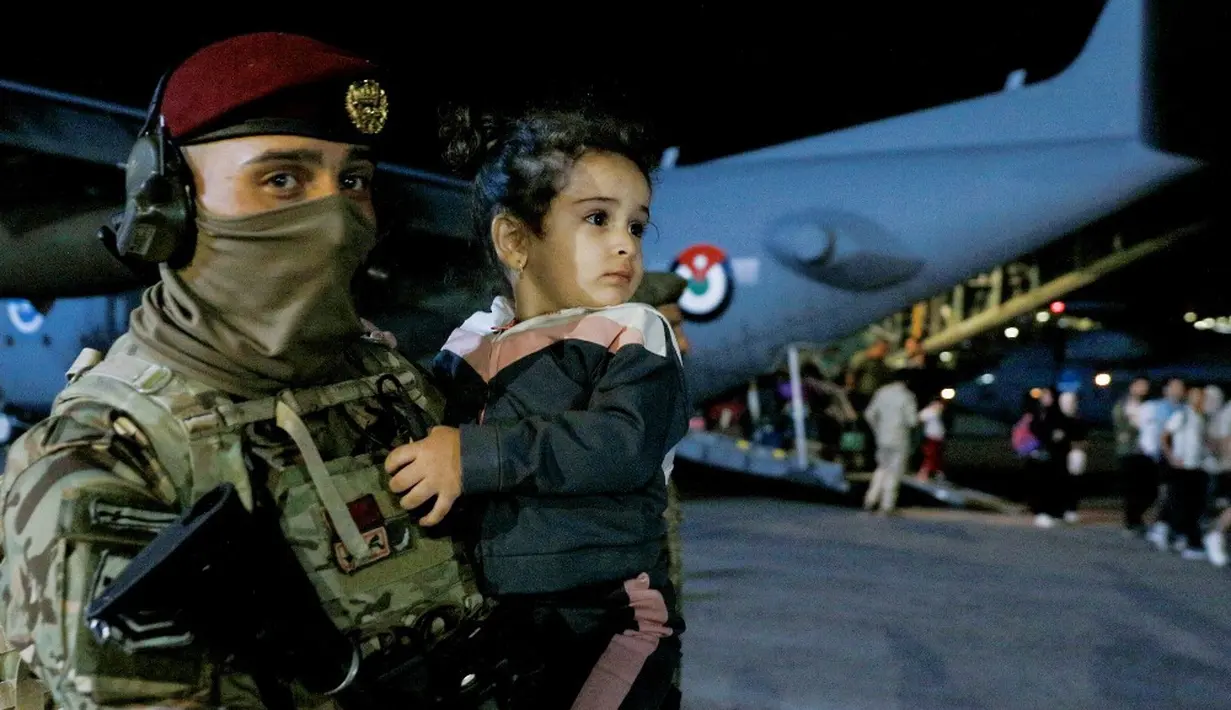 <p>Seorang tentara menggendong seorang anak ketika orang-orang yang dievakuasi dari Sudan turun dari pesawat di bandara militer di Amman, Yordania, Senin (24/4/2023). Negara-negara asing bergegas mengevakuasi warga negara mereka dari Sudan saat pertempuran mematikan berkecamuk memasuki minggu kedua antara pasukan yang setia kepada dua jenderal yang bersaing. (Khalil MAZRAAWI/AFP)</p>