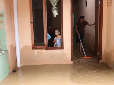 Warga membersihkan rumah mereka akibat banjir yang melanda Kampung Melayu, Jakarta Timur, Senin (25/6). Ketinggian air di Sungai Ciliwung meningkat sehingga merendam sejumlah wilayah di Jakarta. (Liputan6.com/Arya Manggala)