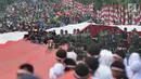 Anggota TNI POLRI  bersama warga masyarakat membawa bendera raksasa berukuran panjang 117 meter dan lebar 5 meter saat gelaran Festival Merah-Putih (FMP) 2018 di kawasan Air Mancur, Bogor ,  Minggu (5/8). (Merdeka.com/Arie Basuki)